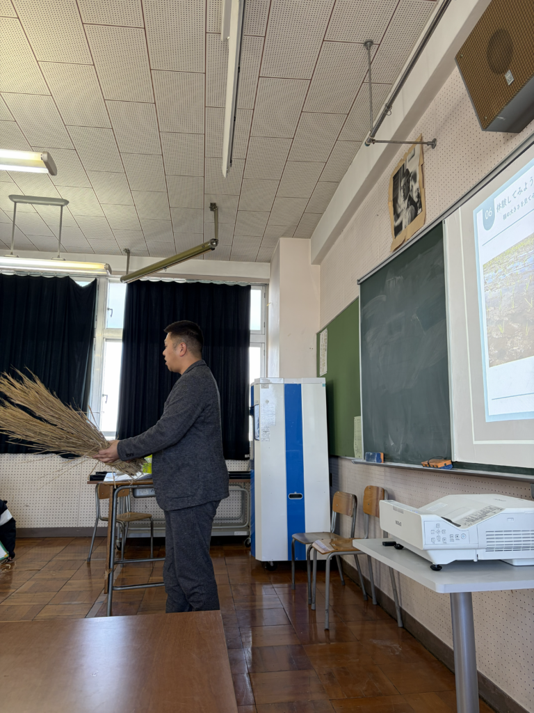 綾瀬市内の小学校で、講義をする様子。稲刈り体験。